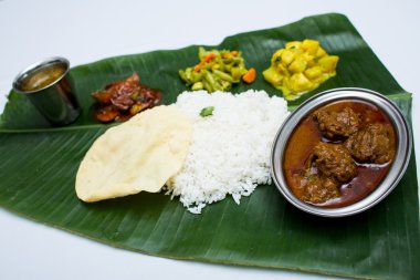 Muz yaprak tepsi üzerinde sade pilav ile Hint koyun eti