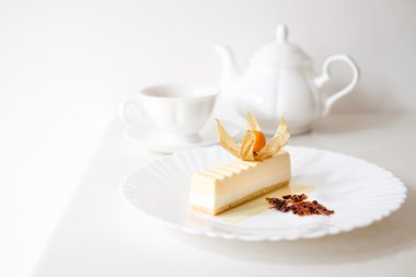 Puding pastası ile çay bardak beyaz plaka üzerinde