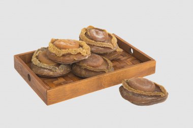 Beyaz arka plan bambu tepsi üzerinde kurutulmuş abalone