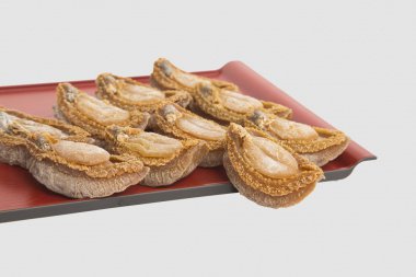 Beyaz arka plan bambu tepsi üzerinde kurutulmuş abalone