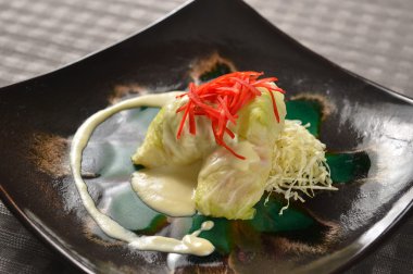 Lahana ile karışık salata siyah plaka üzerinde rulo.