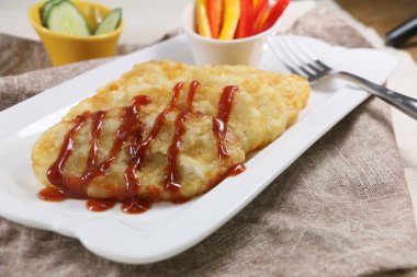 Beyaz tabakta chili soslu çıtır patates kek