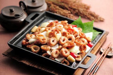 Fried pig intestines in Korean style on black pan clipart