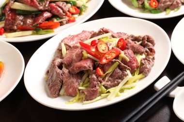 Bıçak kızarmış biber ve soğan restaura beyaz tabakta ile sığır eti