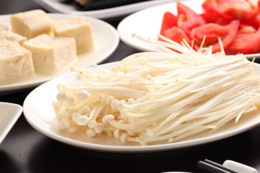 Enokitake mantar tofu ve beyaz tabakta dilimlenmiş domates ile