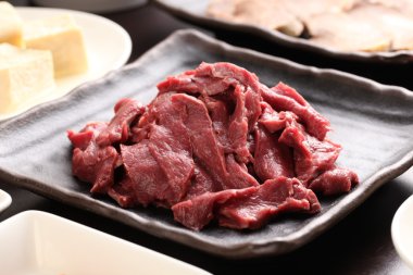 Silced sığır eti kalp ile tofu bir güveç yemek içinde siyah plaka üzerinde