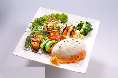 Kızarmış domuz eti pilav, kızarmış balık unu sebze üzerinde beyaz pla ile