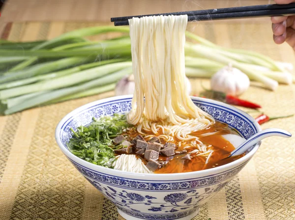 Hot instant noodles with cube beef and herbs on the table — Stock Photo, Image