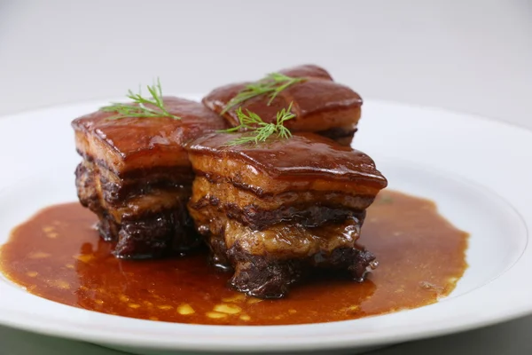 Viande de porc braisée à la chinoise avec des herbes sur assiette blanche — Photo