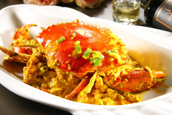 Специальный жареный краб с соусами в китайском стиле на белой тарелке
