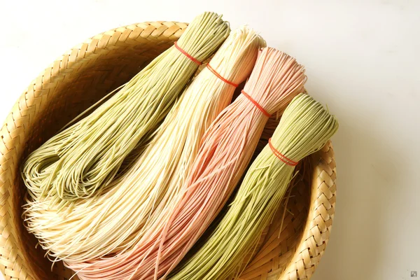 Барвисті китайський спагетті на бамбукових кошика в білому тлі — стокове фото