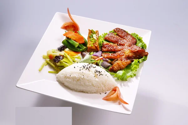 Arroz costillas estofadas con verduras en plato blanco en backgro blanco — Foto de Stock