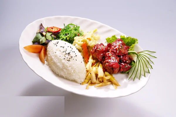 Rusuk beras khamir merah dengan sayuran di piring putih dengan warna putih — Stok Foto