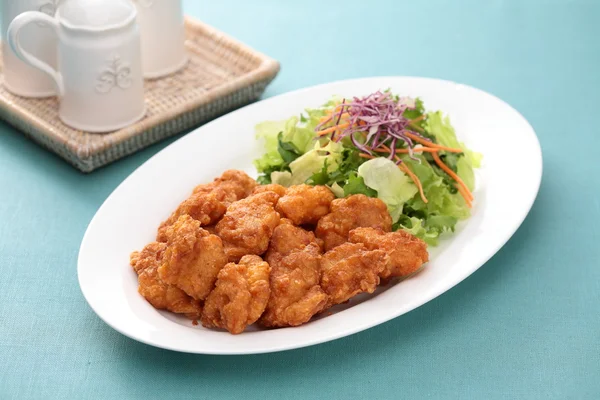 Sunsal goreng Ayam Ambil Ake dengan salad di piring putih dengan teh — Stok Foto