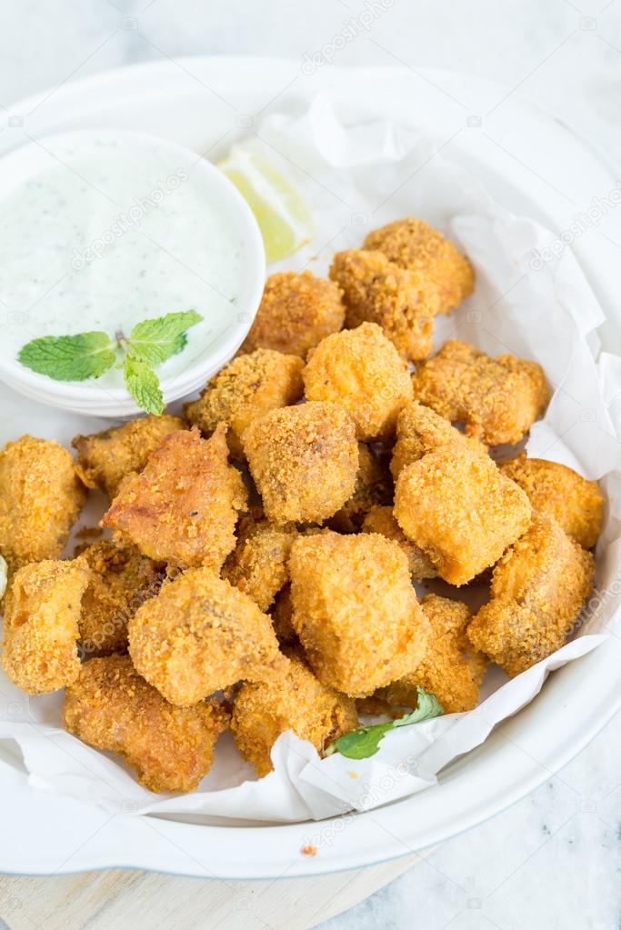 Tortilla crusted baked fish bites on white bowl
