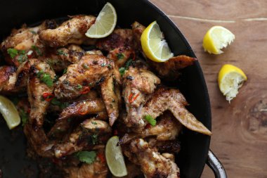 Kum zencefil limon ahşap t üzerinde siyah tavada kızarmış tavuk