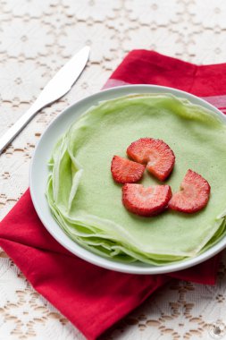 Kırmızı çilek beyaz tabağa dilimlenmiş bıçak ve masa örtüsü