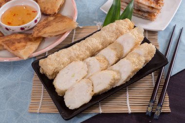 Siyah plaka restoran içinde bambu tepsi üzerinde kızarmış balık yapıştırmak