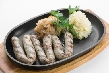 W üzerinde siyah tavada kırmızı biber sosis ile kavrulmuş Türkiye Dana