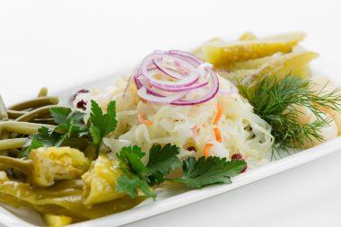 Turşu sebze soğan, otlar ve biber beyaz plaka üzerinde