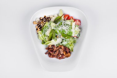 Sezar salatası Pekin ördeği, marul ve otlar beyaz plaka üzerinde 