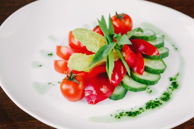 Salata domates, marul, soğan ve salatalık beyaz plaka üzerinde