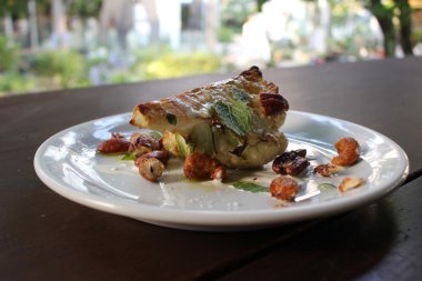 Kavrulmuş dana pirzola kaju ve beyaz tabakta sos ile