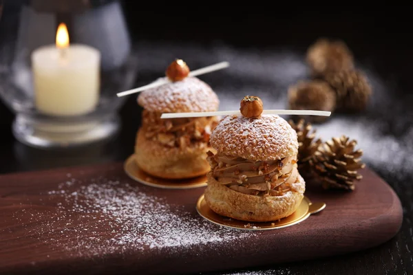 Praline hazelnut choux on wooden tray with pine for Christmas — Stock Photo, Image