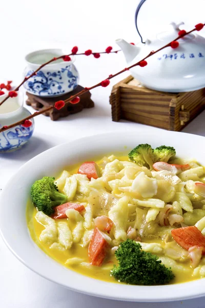 Китайская лапша с брокколи и краб темпура на белой чаше с — стоковое фото