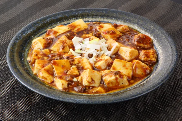 Мабо тофу с томатным супом и луком на китайской тарелке — стоковое фото