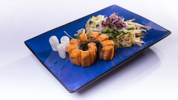 Salade de saumon épicée chaude sur assiette chinoise bleue sur fond blanc — Photo
