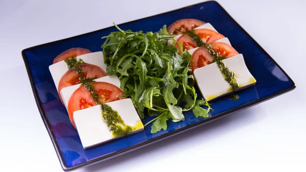 Caprese com tofu na placa chinesa azul no fundo branco — Fotografia de Stock