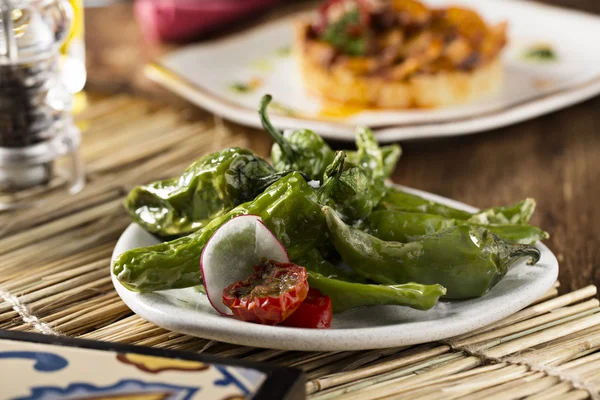 Peperoncino verde fritto su piatto bianco con cipolla — Foto Stock