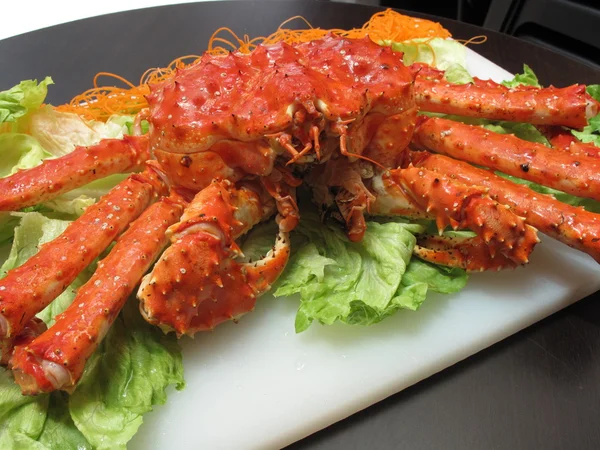 Fried red king crab with lettuce on white plate in restaurant