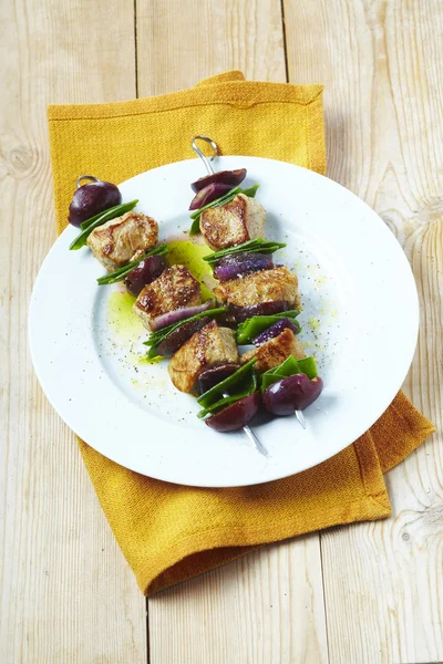 Brochetas de ternera roja y verde en plato blanco en restaurante — Foto de Stock