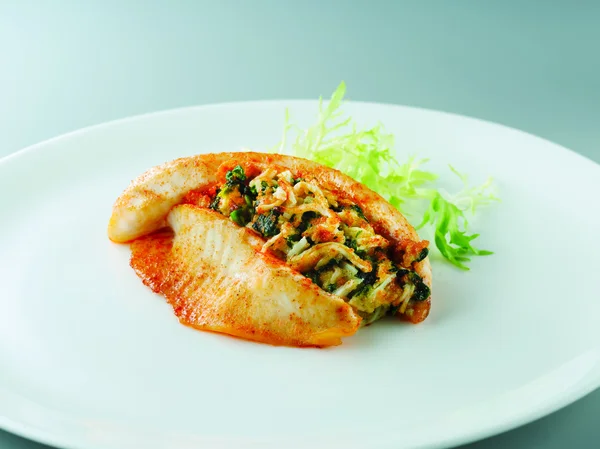 Tilapia rellenas fritas con lechuga en plato blanco en restaurante — Foto de Stock