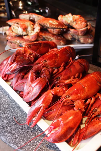 Gestoomde rode kreeften en krabben op witte plaat in restaurant — Stockfoto