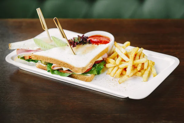 Сэндвич с ветчиной и картофелем и соусом чили на белой тарелке — стоковое фото