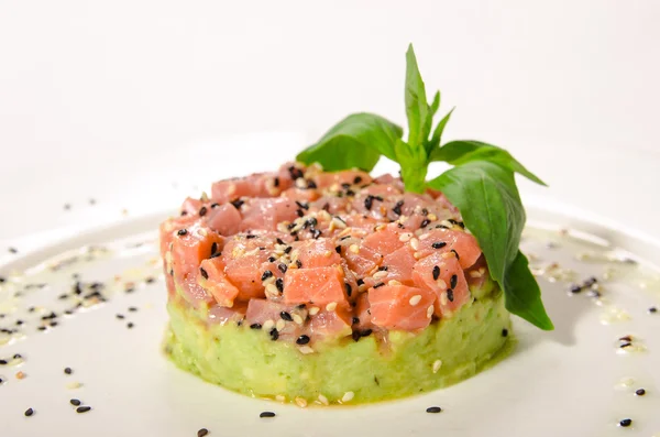 Tártaro de salmão serve com sementes de gergelim em uma cama de legumes — Fotografia de Stock