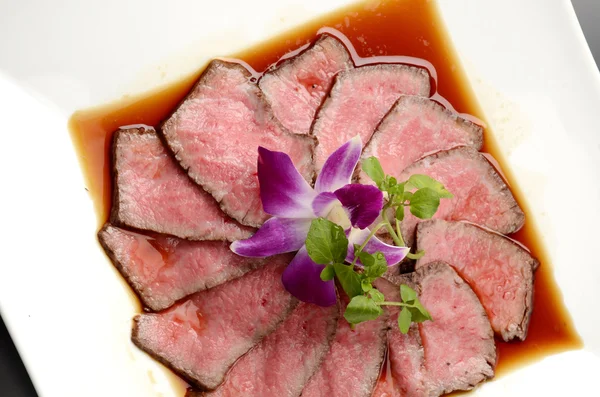 Carne asada fresca en plato blanco con hierbas en el restaurante — Foto de Stock