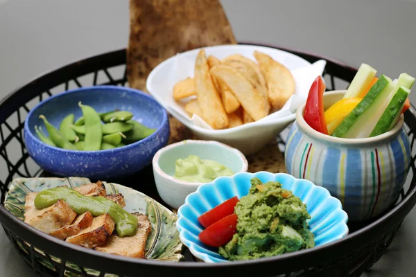 Cesta de comida con papas fritas, puré de aguacate, cucuc en rodajas — Foto de Stock