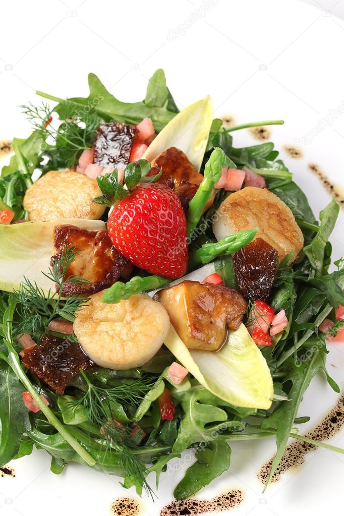 Scallop salad with strawberry and lettuce herbs on white plate