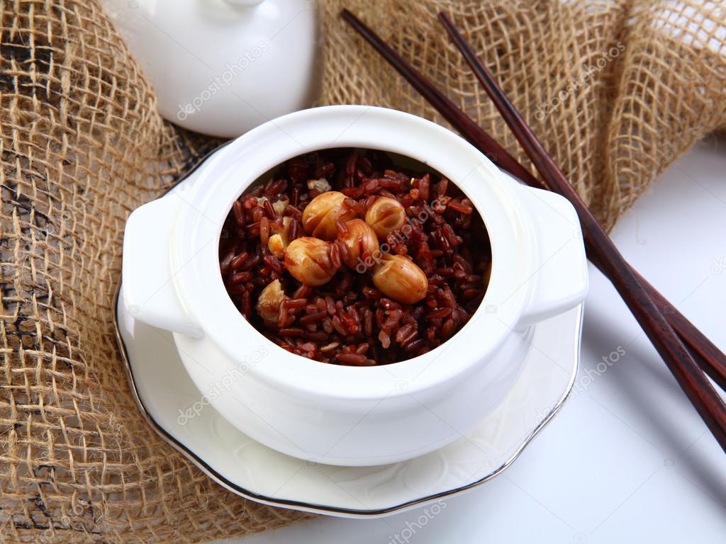 Red sticky rice with lotus bean on white bowl in restaurant