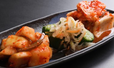 Kimchi çeşitli fermente turp ve salatalığın üzerinde siyah plat