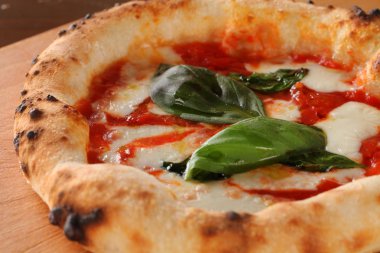 Ahşap masa üzerinde sıcak biber ve domates soslu kızarmış pizza