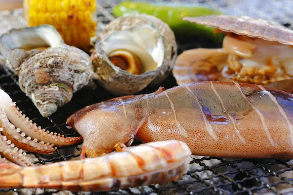 Grillen Seeohr, Tintenfisch, Garnelen, Venusmuscheln und Mais mit heißem Kakao — Stockfoto