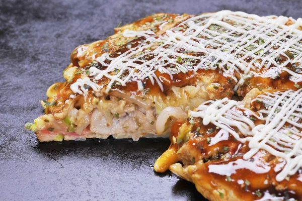 Traditional Japanese okonomiyaki pancake on hot black pan — Stock Photo, Image