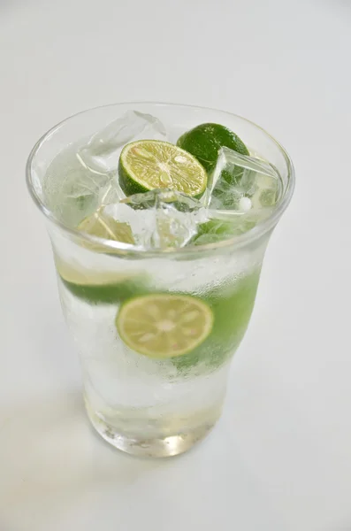 Стакан зеленого сока кумквата с холодным льдом на белом фоне — стоковое фото
