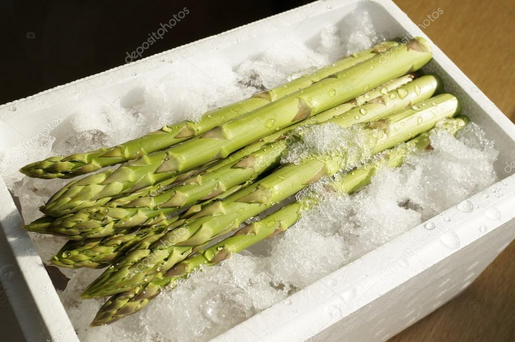 Farm packing in ice fresh asparagus on wooden table