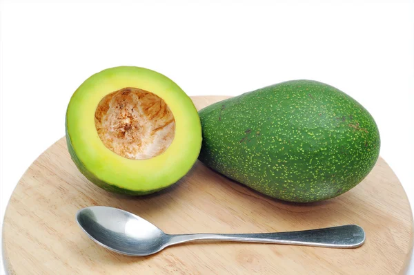 Avocado op de snijplank met lepel op een witte achtergrond — Stockfoto